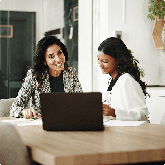 Two women collaborating at a laptop.