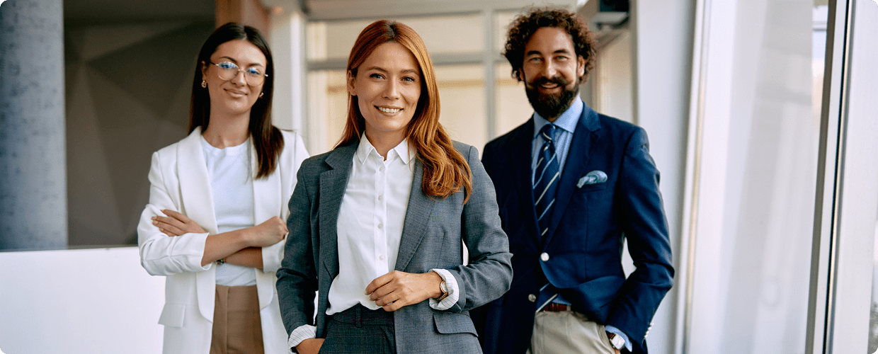 Three professionals smiling in an office setting.